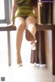 A woman sitting on top of a wooden table with her legs crossed.