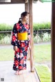 A woman in a kimono standing on a porch.