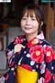 A woman in a kimono poses for a picture. 